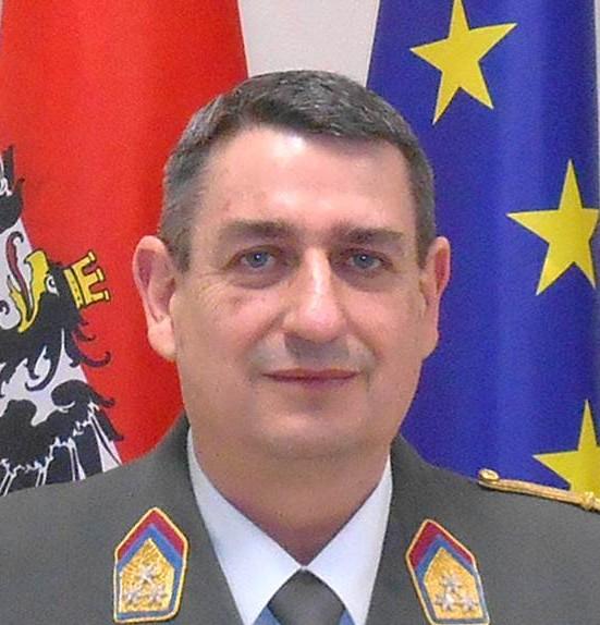 Col Harald Gell in an Austrian Army uniform in front of the Austrian and Europe flag.