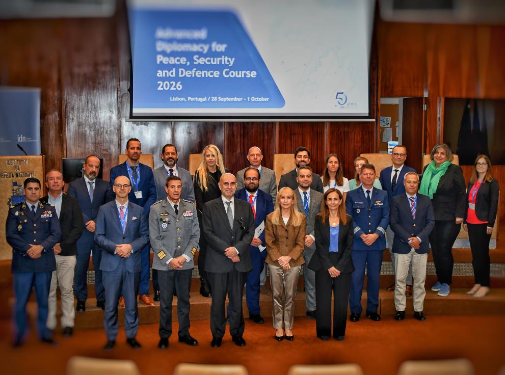 Group of people, some in civilian cloths and military uniforms standing orderely for a group picture. 